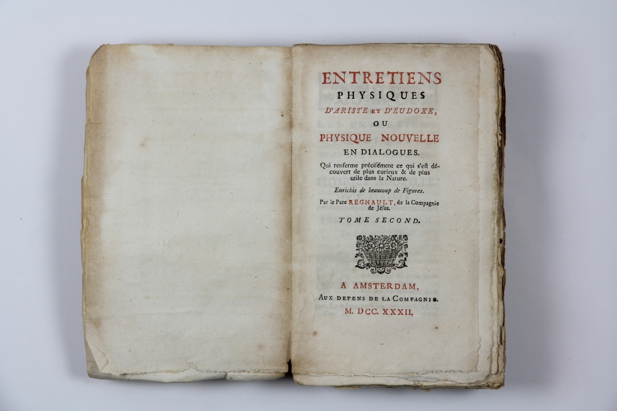 Bok, pappband, "Entretiens physiques d'Ariste et d'Eudoxe, ou Physique nouvelle en dialogues" utgiven i Amsterdam 1732. Med planscher i kopparstick. Marmorerat band med blekt rygg, blekt titelpåskrift ( svårläst) och klistrade etiketter med volymens nummer. Skurna snitt.