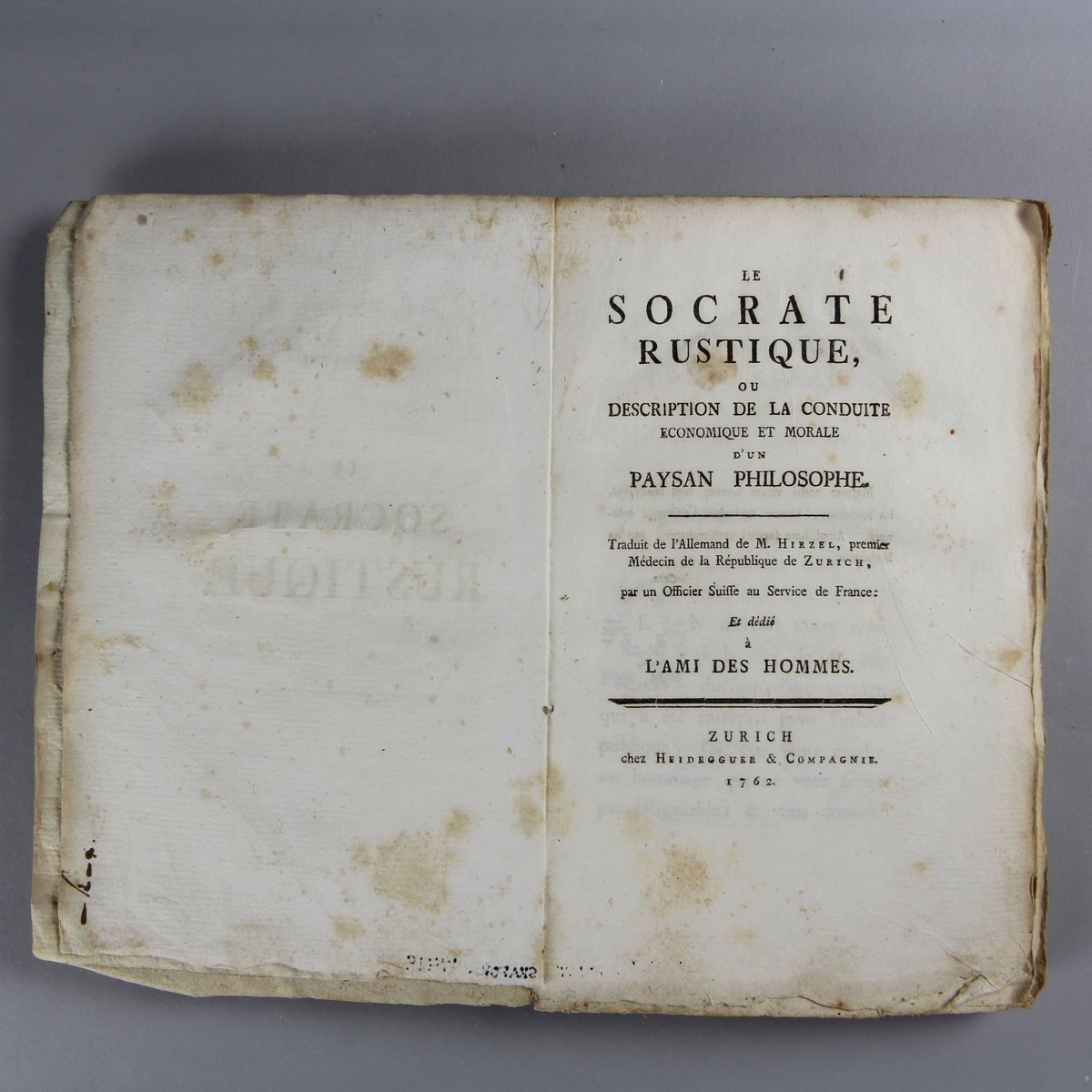 Bok, häftad,"Le Socrate rustique",  tryckt i Zürich 1762.
Pärm av gråblått papper, oskurna snitt. Blekt rygg med pappersetikett med volymens namn och samlingsnummer.