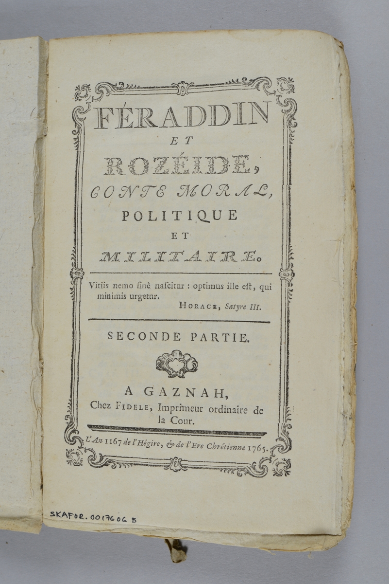 Bok, pappband,"Féraddin et Rozéide, conte morale, politique et militaire", del 2,  tryckt 1765 i Gaznah.
Pärm av gråblått papper, oskuret snitt. På ryggen pappersetikett med volymens namn och nummer. Ryggen blekt.