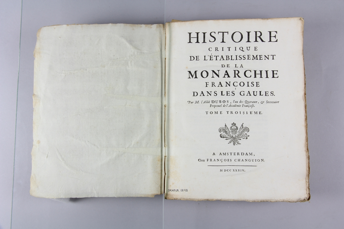 Bok, häftad "Histoire critique de l'établissement de la monarchie françoise dans les Gaules." del 3. Pärmar av marmorerat papper, blekt och skadad rygg med etikett med samlingsnummer. Oskuret snitt.