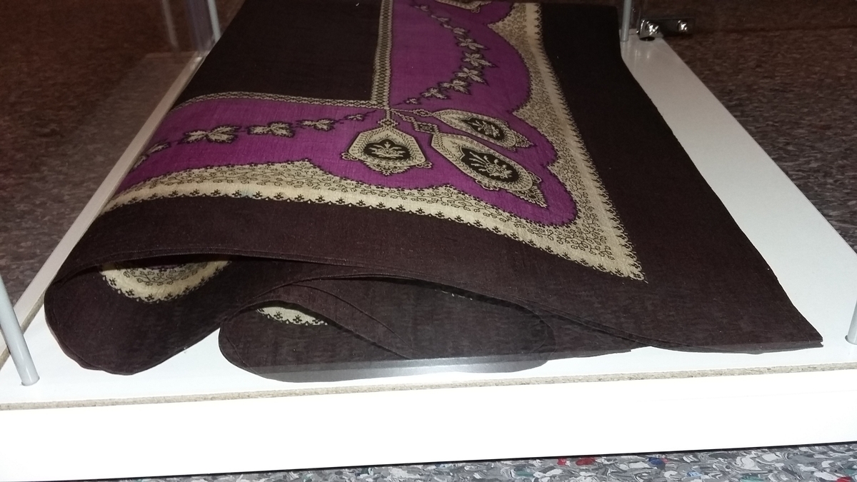 Bord langs alle fire kanter med bladverk, stiliserte blomster og geometriske figurer.