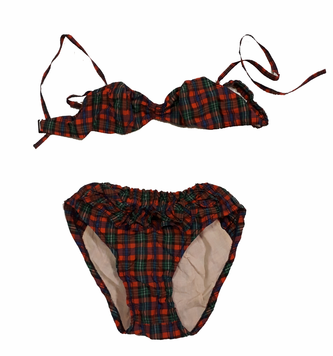 Blommig säck av galontyg innehållande badkläder: rutig bikini, blå badbyxor och blå/rosa bikinibyxor. Medföljde vid insamlingen av Vegkryssaren TERTIA.