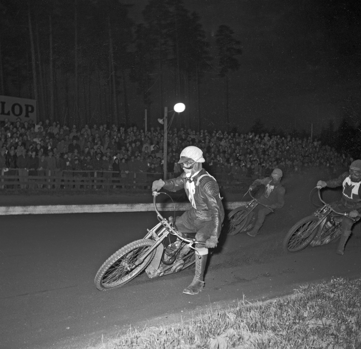 Fartfyllt ögonblick från östgöta-derby mellan rivalerna Filbyterna och Vargarna. Just denna kamp avgjordes på Linköpings motorstadion till hemmalagets fördel den 24 april 1953.