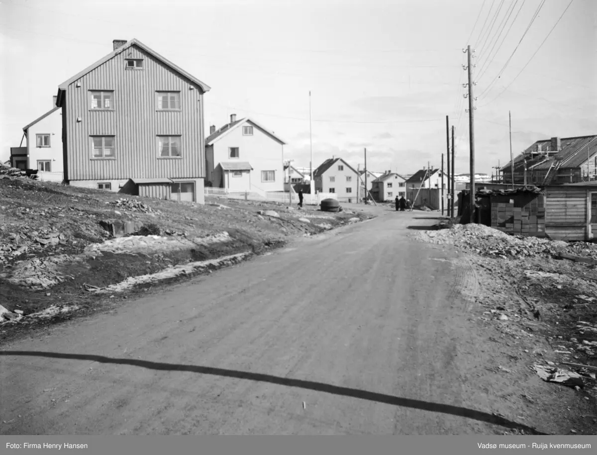 Vadsø 1951. Gatepart med flere gjenreisningshus. Nyborgveien nærmest som går over i Oscarsgate ved krysset i bakgrunnen. Bildet er tatt mot øst, Navarsodden / Kibysvingen sees.