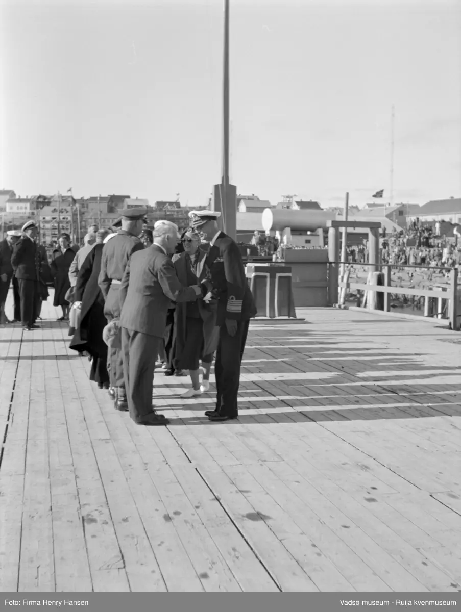 Vadsø. Kongebesøk i Vadsø 1950. Kongen og kronprinsfamilien er kommet med sjalupp fra kongeskipet, her blir de tatt imot på kaia.
Kong Haakon og kronprinsfamilien besøkte Vadsø 25.-26.7.1950 i forbindelse med en større rundreise i Nord-Norge sommeren 1950. Under besøket sto "biltur gjennom byen" og "besøk på sykehuset" på programmet. Kilde: Det kongelige hoff, arkivet