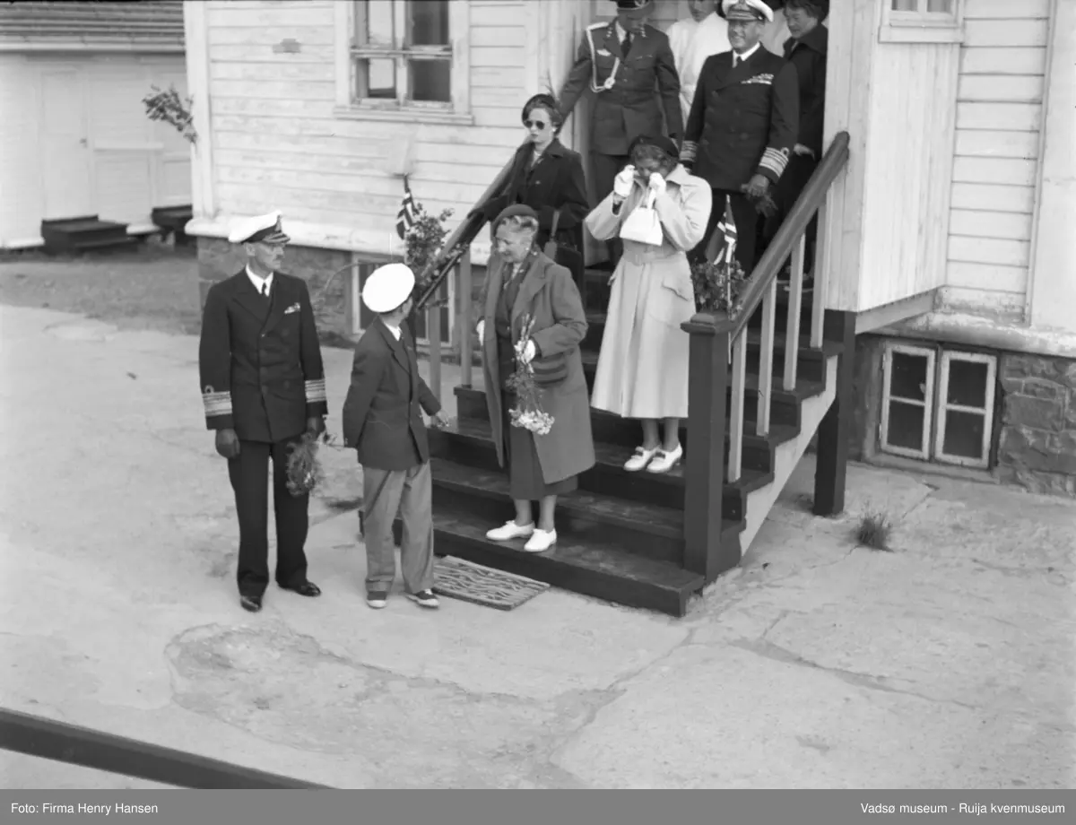 Vadsø. Kongebesøk i Vadsø 1950. Kong Haakon, prins Harald, kronprinsesse Märtha og prinsesse Astrid forlater en bygning. 
Kong Haakon og kronprinsfamilien besøkte Vadsø 25.-26.7.1950 i forbindelse med en større rundreise i Nord-Norge sommeren 1950. Under besøket sto "biltur gjennom byen" og "besøk på sykehuset" på programmet. Kilde: Det kongelige hoff, arkivet