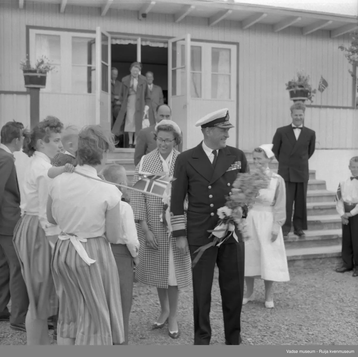 Vestre Jakobselv juli 1959. Kongebesøk på barnehjemmet Vårsol.Følget forlater Vårsol. Til venstre for Kongen: Prinsesse Astrid, bak prinsessen står ordfører Henry Karlsen. Til høyre for Kongen søster Gunvor og Anaton Strand.