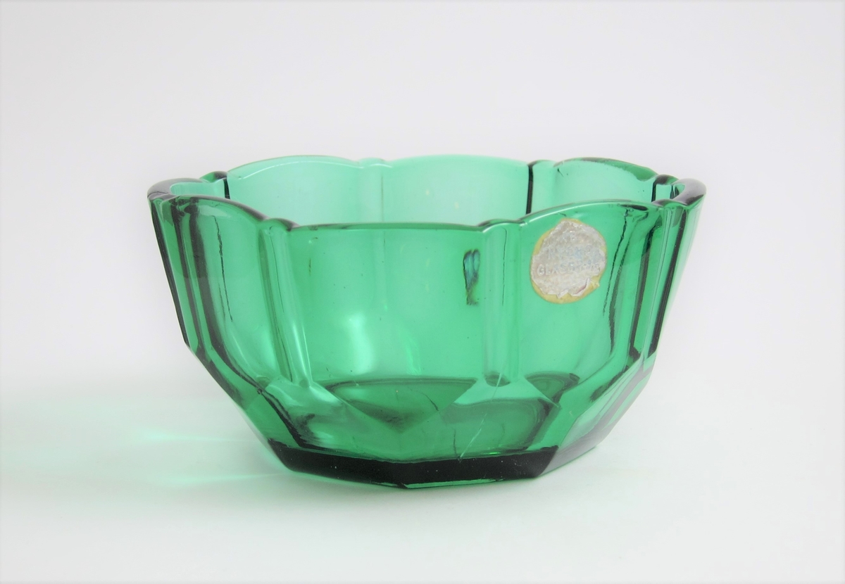 Sockerskål
Fyrkantig med rundade hörn. Runt skålen facett- och skärslipimitation.
Etikett: Sliten, helt i silver: AB NYBRO GLASBRUK.