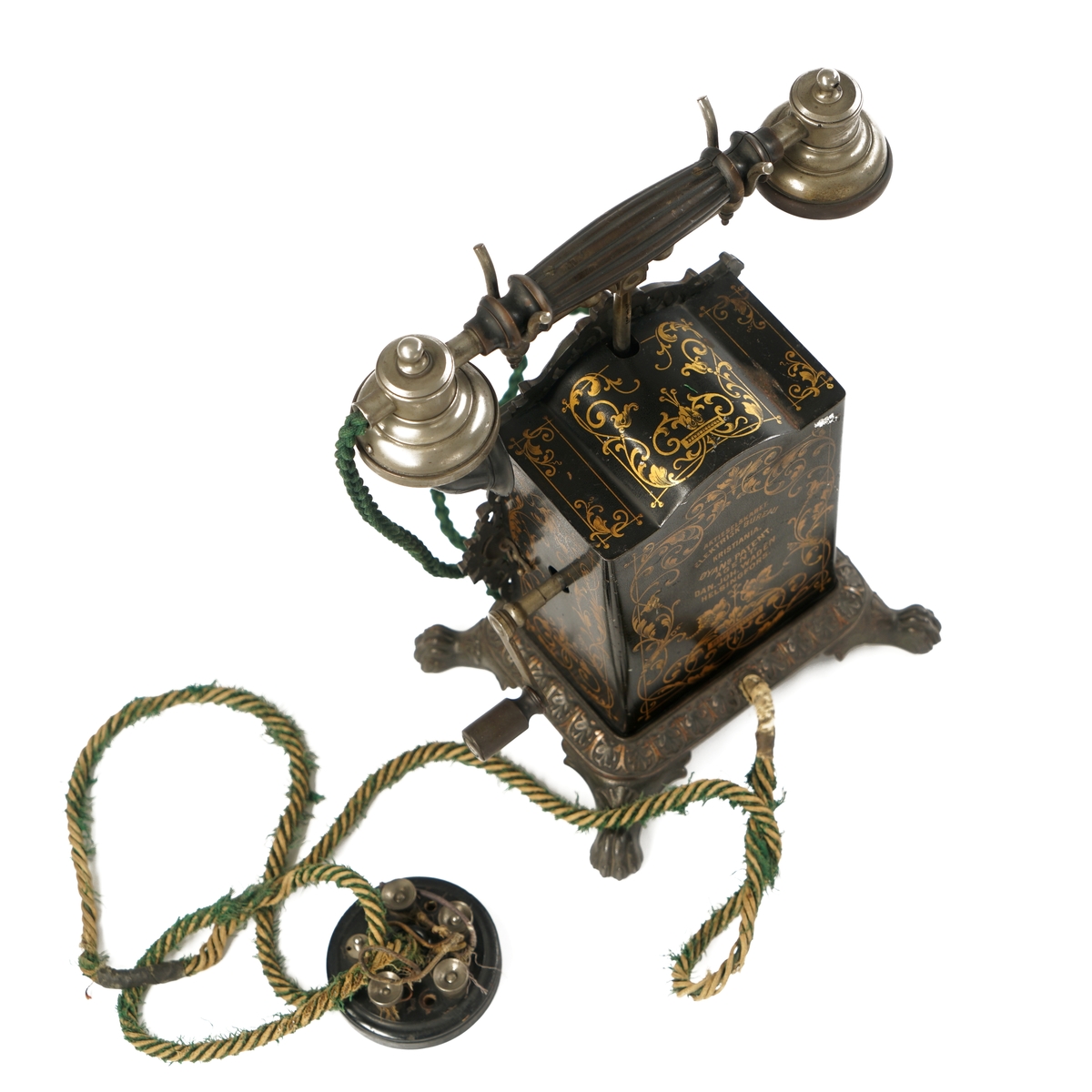 Telefonapparat med koblingsskive. Sort og gull med forsiringer.