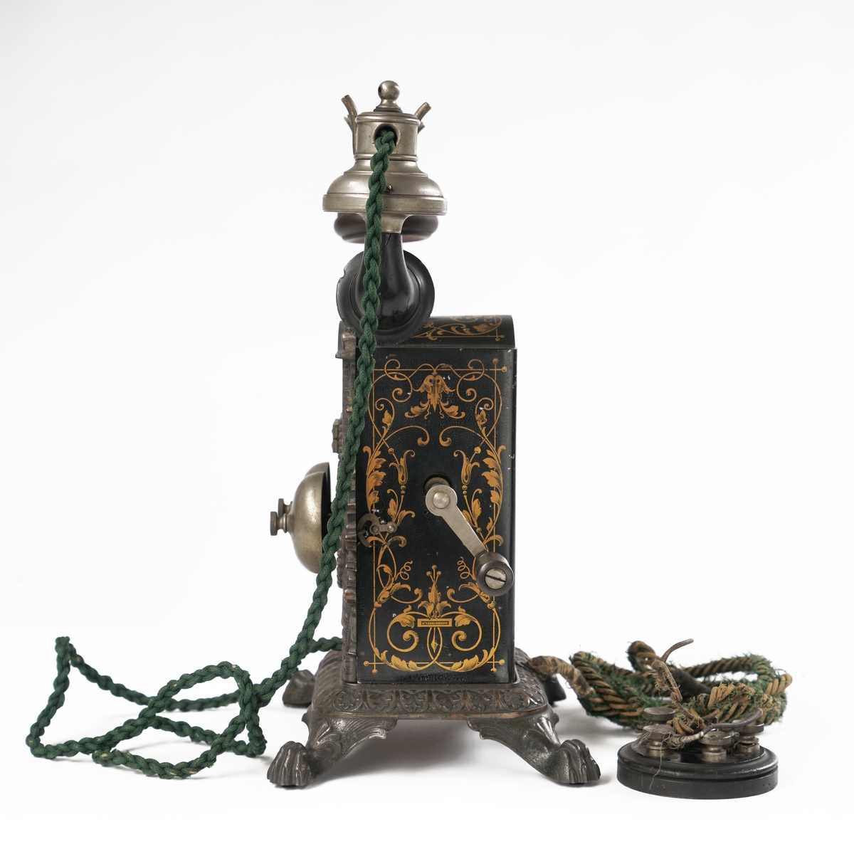 Telefonapparat med koblingsskive. Sort og gull med forsiringer.