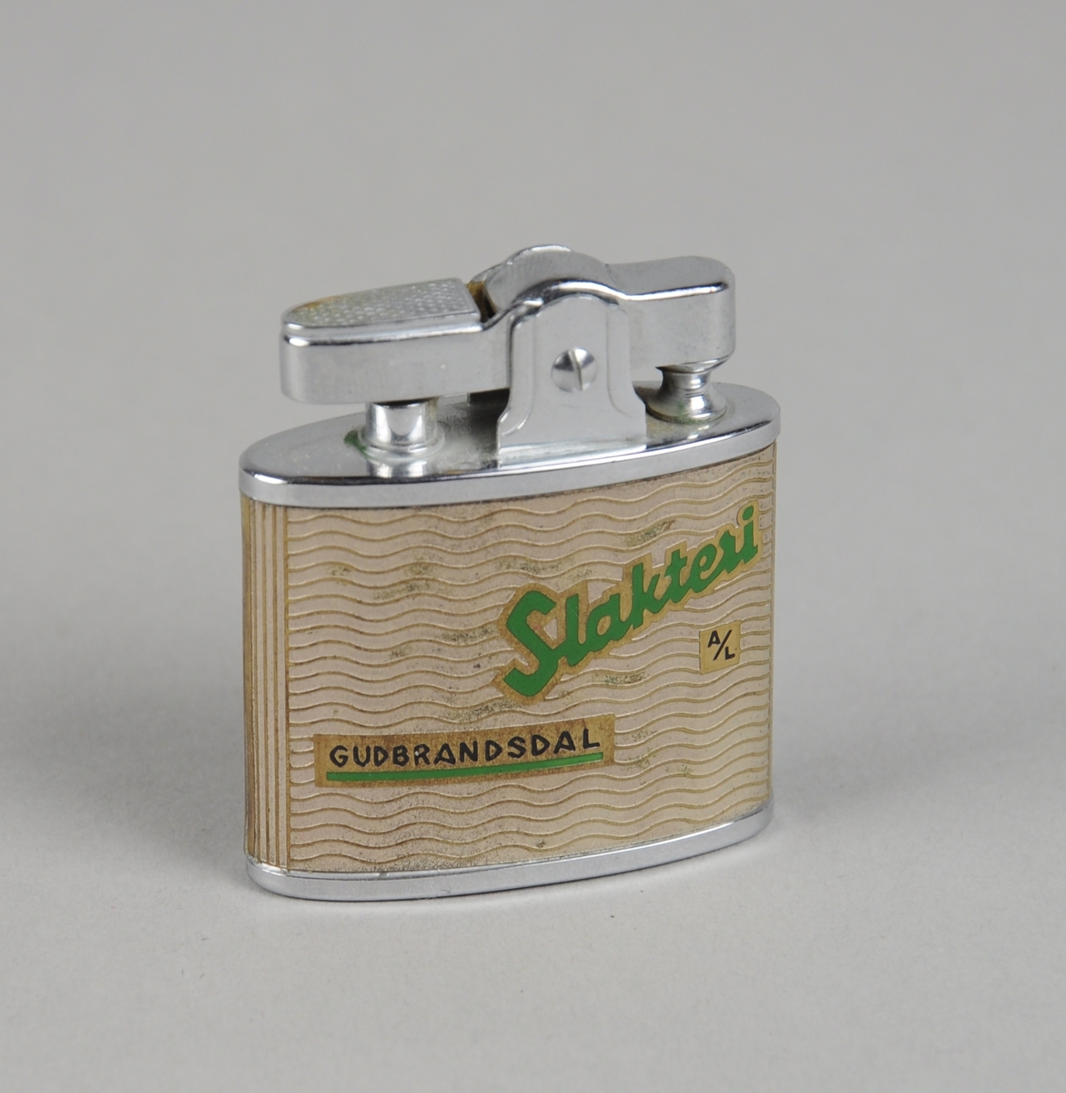 Lighter som kan etterfylles med gass. På baksiden er det trykket et kart over Oppland.