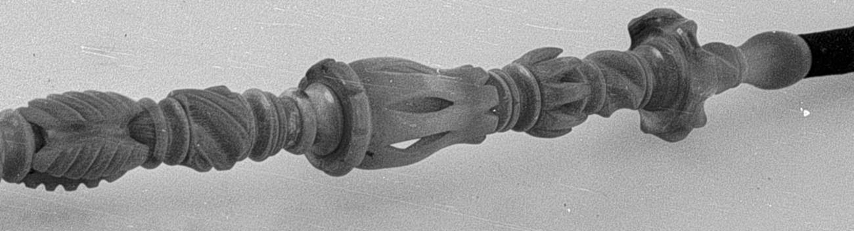 Langpipe i tre deler: Piperør, pipehode og munnstykke. Pipehodet av porselen  er påmalt et skogmotiv med en elg, og harr lokk av sølv. Piperøret og munnstykket er av utskåret alabast. Det midtertste partiet på munnstykket er bøyelig.