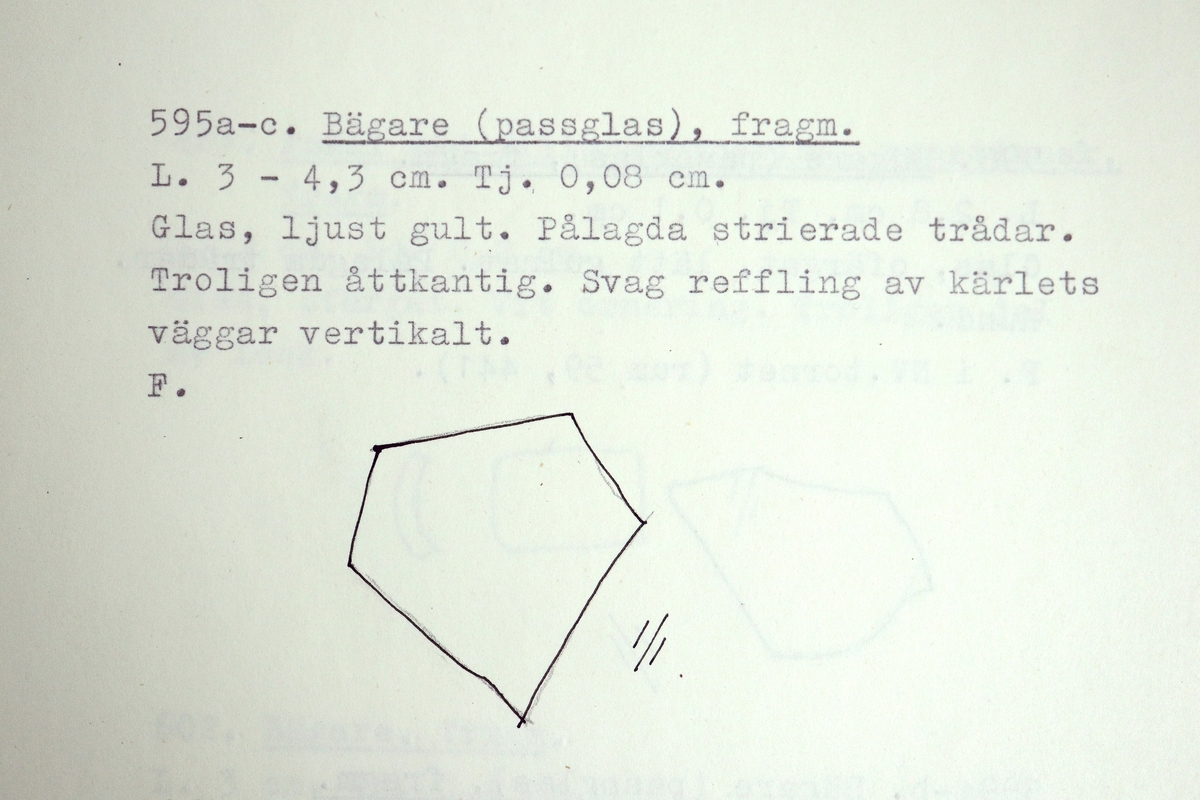 Tre delar av ett brungult, mångkantigt och optikblåst passglas med pålagda strierade trådar.