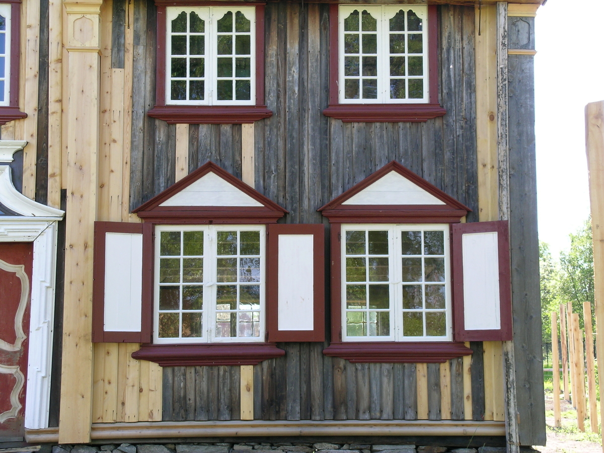 Bergmannsbolig av tømmer. Kledd med tømmermannspanel på gatefasaden. Taket er tekt med never og torv. Fasadeutstyret mot det offentlige rom holder en veldig høy standard. Bygningen er satt sammen av flere (to) eldre bolighus. Den tverrstilte midtarken er sekundært plassert oppå de sammenstilte bygningskroppene. Boligen fra Aspåsgården er sannsynligvis påbegynt  tidlig på 1700-tallet. Senere utvidet og mye forandret. Blant annet er det påbygd to omfar i hele 2. etg. og det er også satt inn større vinduskarmer. Trolig er dette skjedd i siste del av 1800-tallet. Det er gjenbrukt bygningselementer fra et sosialt høyere sjikt. Bygningen har to rom med fyllingspanelte vegger. - Et  rom i 2. etg. og et i midtarken. Disse to rommene har fått sine nytilvirkede veggpaneler etter at de har fått nåværende romhøyde og etter at det er satt inn større vinduskarmer. Bygningen er endret helt inn mot 1900-tallet.  Pløyd panel, brukt i bislag mot bakgården, representerer et siste trinn i Rørosbebyggelsens utviklingshistorie. Sto på Flanderborg, Røros. Gjenreist på Sverresborg 1917. I forbindelse med oppføringa på museet har bygningen vært gjenstand for omfattende tilbakeføringsforsøk, med blant annet ens vindusrammer for hver etasje. Ikke noe av det gamle panelet på gatefasaden er gjenbrukt. Nytt panel har også fått en annen utbredelse og underdeling enn tidligere. På Røros var bl. a. også grundmuren dekt av panel. Alt tømmermannspanel er nytt fra 1917. Dagens utseende er eksteriørmessig utvilsomt museumsskapt. Endringene, som er gjennomført på museet, har bidratt til klart å svekke et veldig godt eksempel på folkelig, lokal byggeskikk. 