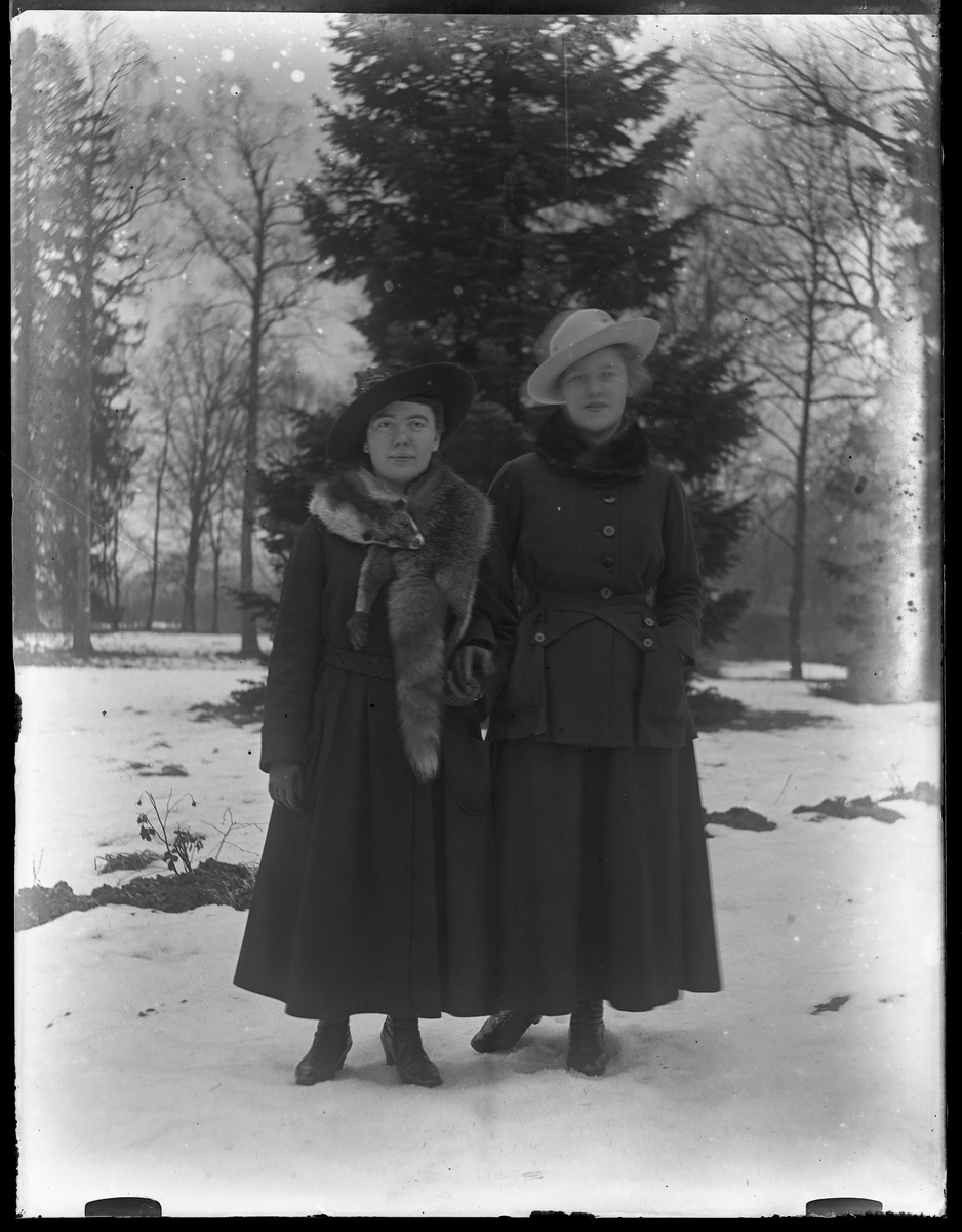 Signe och Eva fotograferade hand i hand ute i snön.