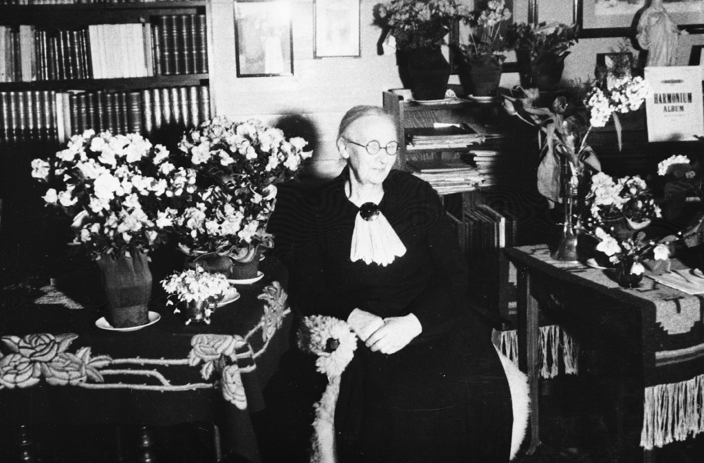 Bolette Henrikke Hognestad f. Seland (1868 - 1959) i stova med blomar på 70-årsdagen, 4. mars 1938