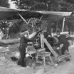 Reparation av motor på flygplan Gloster Gladiator gul I vid F 19, Svenska frivilligkåren i Finland. Två mekaniker i arbete.