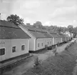 Motiv från Bruksgatan i Finspång 1953. Från 1764 kom Finspångs bruk att uppföra dessa sju arbetarebostäder i rad. År 1818 uppfördes även ett värdshus i gatans ände.