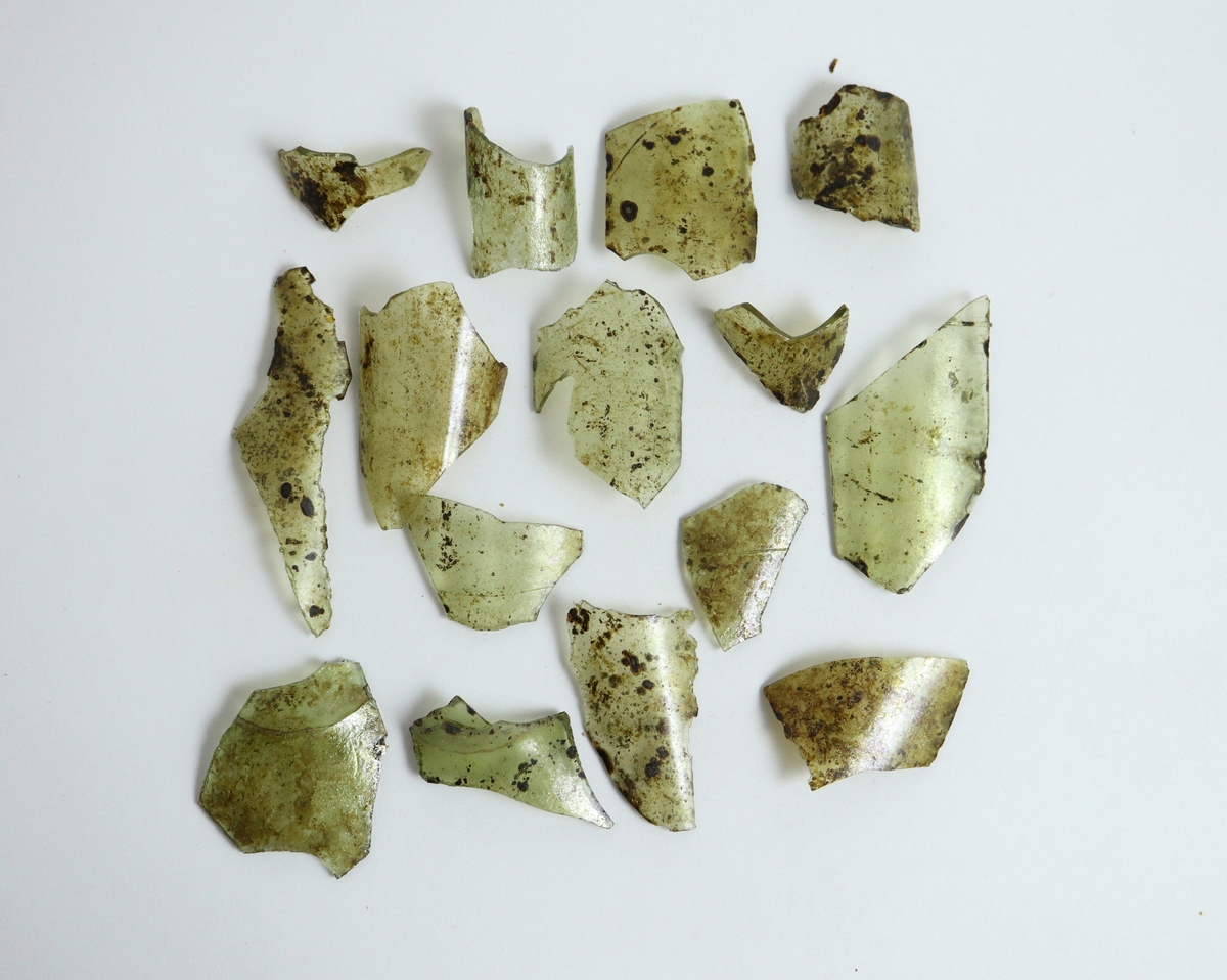 15 fragment av ett kägelformat passglas med mycket tunna trådar. Glasmassan är lätt gröntonad men nu brunfläckig. Bottnen har invändigt varit konisk. Käglans nedre del är 16 mm i diameter. Skärvan M 17000-643 m är i två delar. Mycket lik M 17000-576 i glasmassan.

M 17000-643 valdes ut för ICP-analys i maj 2023.