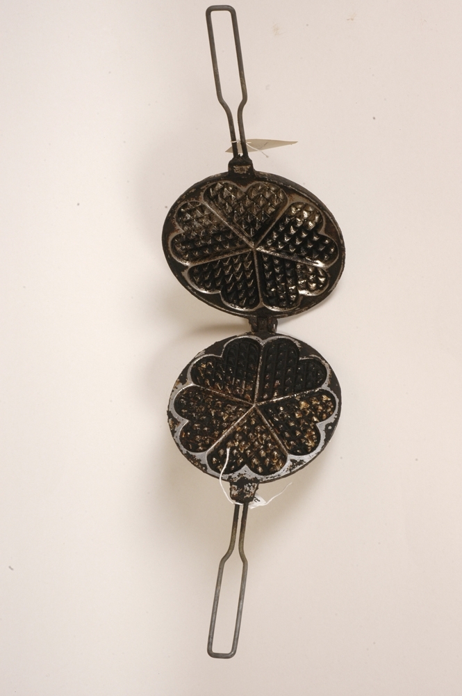 Vaffeljernet er dobbelt og hengslet bak. Jernet er rundt m/ 5-hjerters rutemønster og lange håndtak.