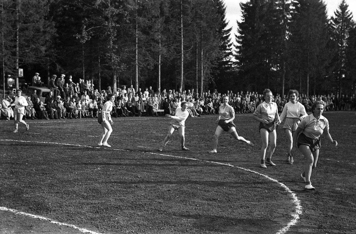 Håndballkamp på Kraby Idrettsplass september 1953. Kampen var kvartfinale i damenes Norgesmesterskap mot Nornen fra Bergen, en kamp Kraby vant og dermed kvlifiserte seg for semifinale. Krabys spillere, i de mørkeste buksene, er identifisert, men for navn henvises til lagbilde TMF-06483.
14 bilder som viser kampsituasjoner og publikum.