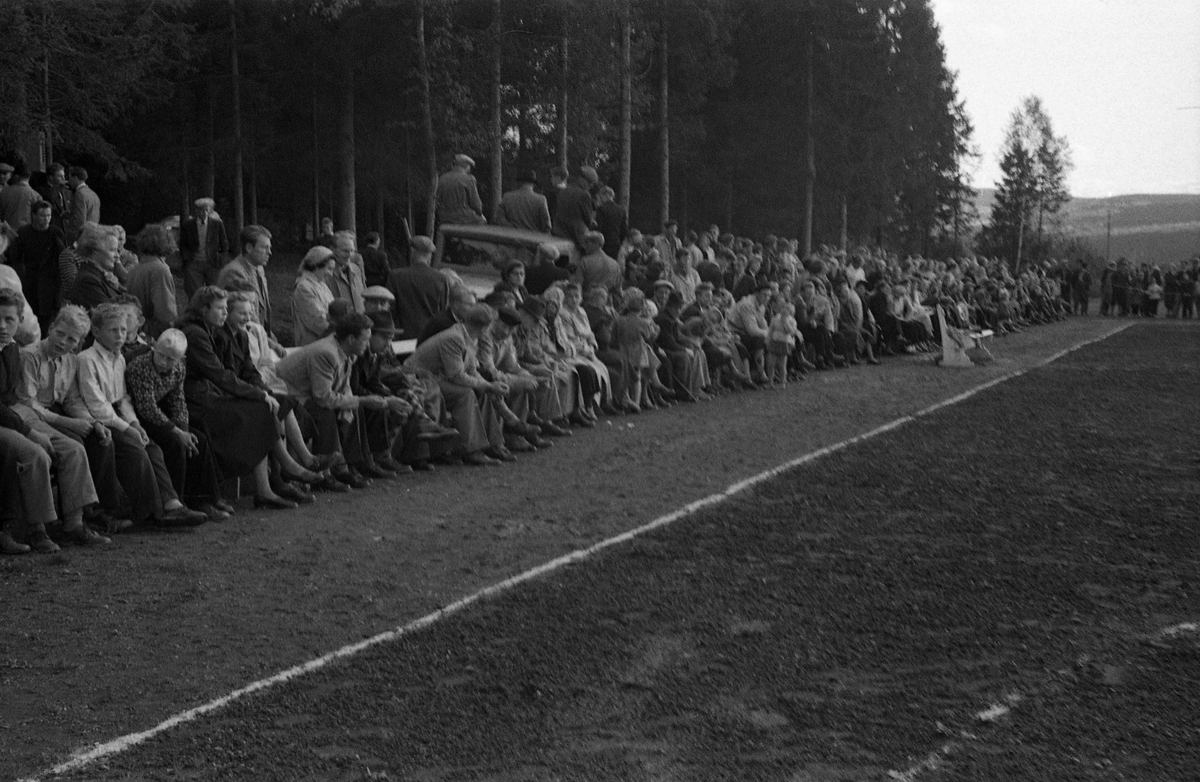 Håndballkamp på Kraby Idrettsplass september 1953. Kampen var kvartfinale i damenes Norgesmesterskap mot Nornen fra Bergen, en kamp Kraby vant og dermed kvlifiserte seg for semifinale. Krabys spillere, i de mørkeste buksene, er identifisert, men for navn henvises til lagbilde TMF-06483.
14 bilder som viser kampsituasjoner og publikum.