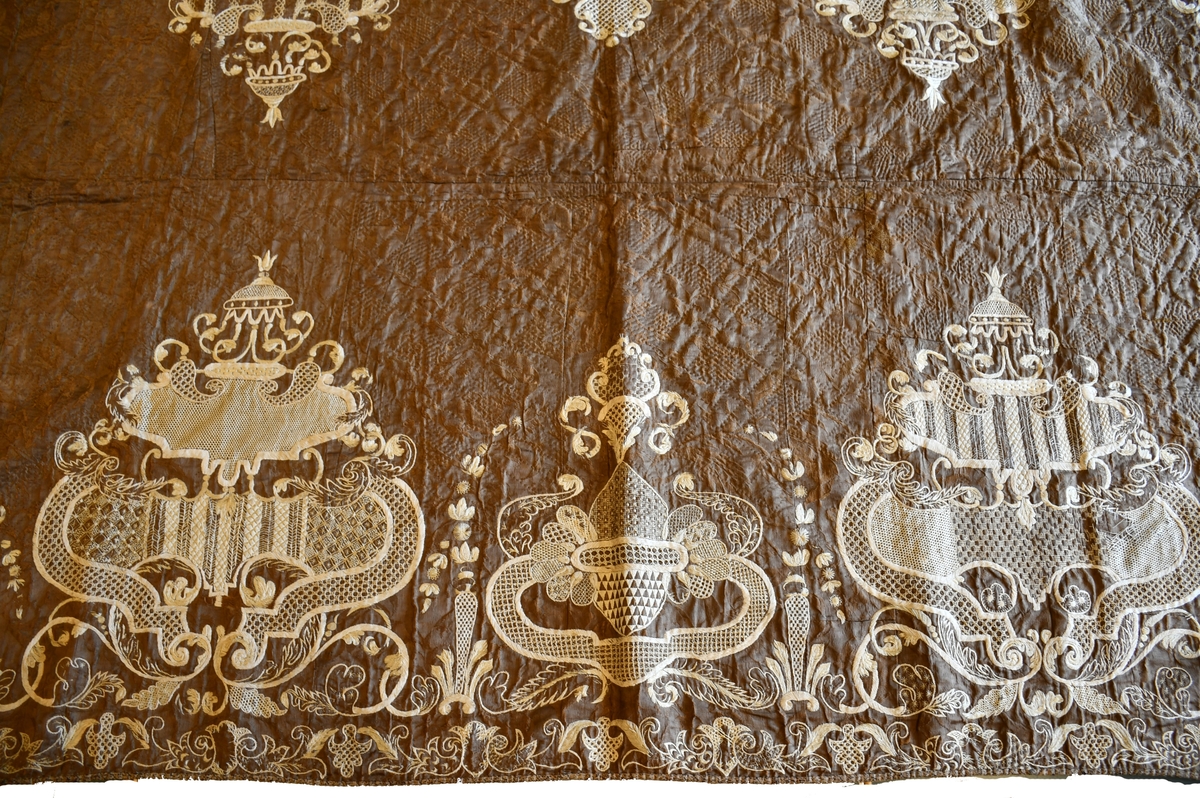 Täcke med broderier.