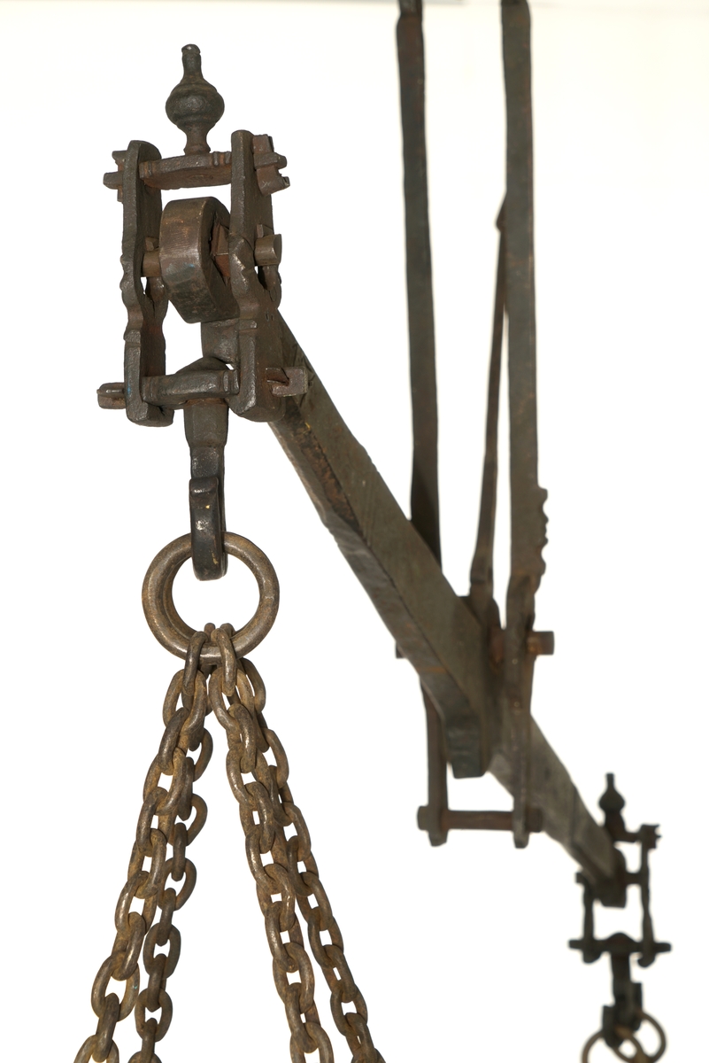 To vektskåler av tre, beslått med jernbeslag. Kjetting i alle hjørner som samles i en opphengsring.