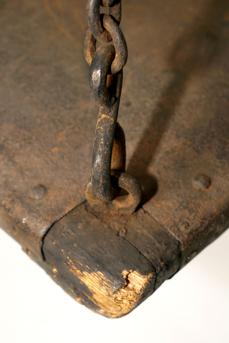 To vektskåler av tre, beslått med jernbeslag. Kjetting i alle hjørner som samles i en opphengsring.