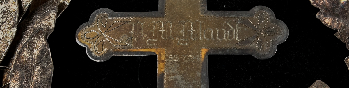 Sølvkrans av laurbær og eikeløv med sløyfe nederst. Mellom de bøyde greinene er det et sølvkors. Kransen er sydd ned på en svart fløyelspute med dusker i hjørnene. Sølvsnor påsydd rundt puta.

Det finnes to like kranser som denne publisert på Digitalt museum. Den ene er udatert, men den andre er også produsert i 1924 - og befinner seg på Mjøsmuseet.