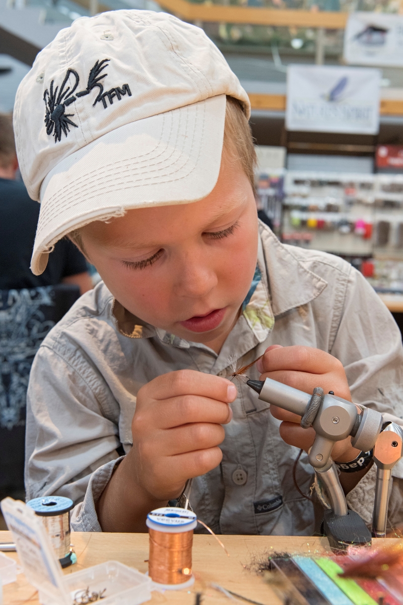 Fluebinding. Fluebinder Ole Litlere' Rydgren (6 år) binder ei døgnflue under De nordiske jakt- og fiskedager 2018.