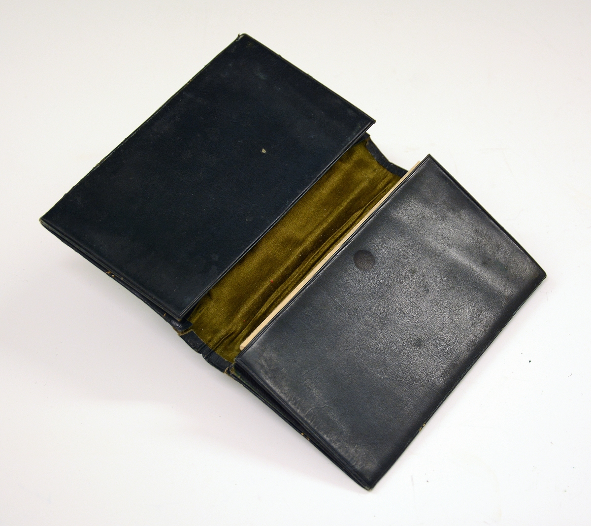 Liten lommebok i grønt skinn med to rom, mosegrønt fôr. Utsiden med preget dekorrender i gull. En side mangler sømmen.
Innlagt konvolutt med to resepter fra Henrik Ibsens privatlege, Dr. med. Edvard Bull. Den ene resepten datert 14/3 1903. En tredje resept, italiensk, datert 31. mai 1897.