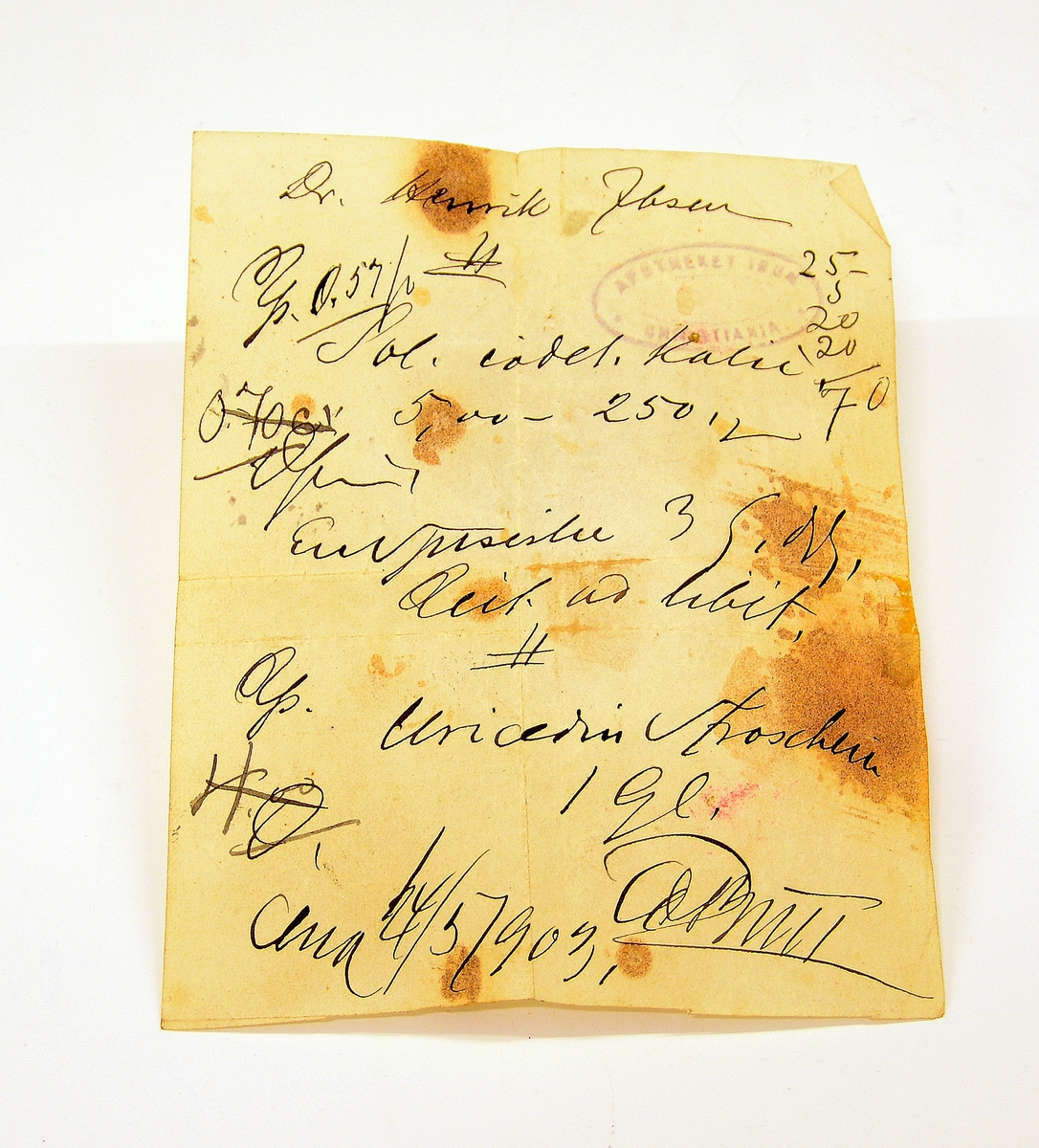 Liten lommebok i grønt skinn med to rom, mosegrønt fôr. Utsiden med preget dekorrender i gull. En side mangler sømmen.
Innlagt konvolutt med to resepter fra Henrik Ibsens privatlege, Dr. med. Edvard Bull. Den ene resepten datert 14/3 1903. En tredje resept, italiensk, datert 31. mai 1897.