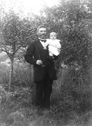 Portrett av mann med lite barn på armen, langpipe i andre hå