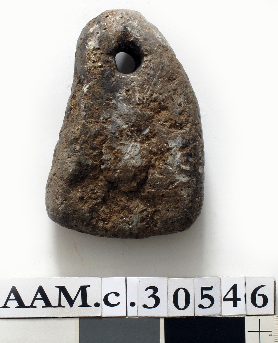 Kljåstein av kleber, av noe uregelmessig trekantet form. Bærehullet i toppunktet. Grovt tildannet, men bra bevart. Lengde 11,5 cm, st. bredde 8 cm.
