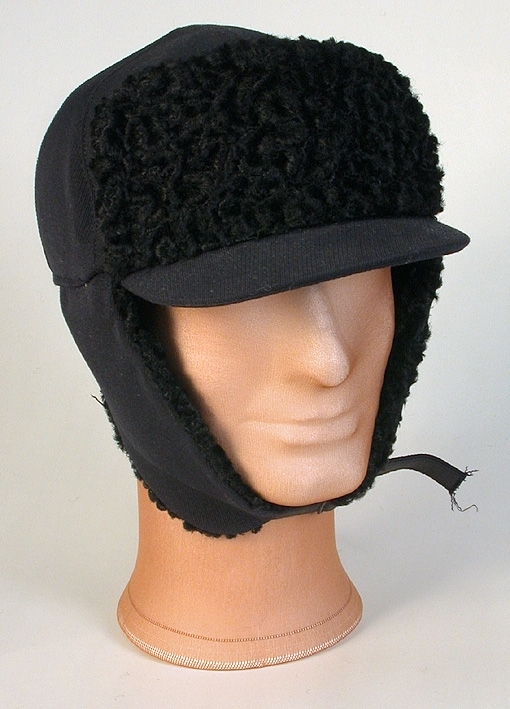 Sportmössa för man av blått ylletyg, kilskuren kulle. Tygklädd skärm. Uppvikt brätte klätt med krimmer. Påsydd prislapp. 
Mått: Runt kullen 590 mm. Kullens höjd 90 mm. 
Storlek: 61.