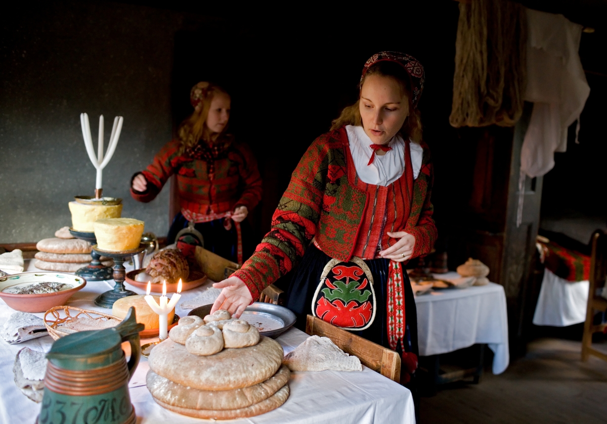 Interiör från en Skansenmiljö. Dukat julbord i Delsbogården, pedgagog klädd i folkdräkt.