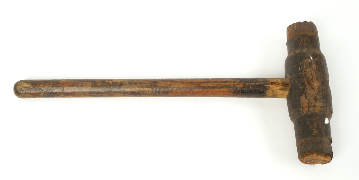 Klubbe av tre hvor klubbehodet  er avlangt og rundt med slagsider i hver ende.