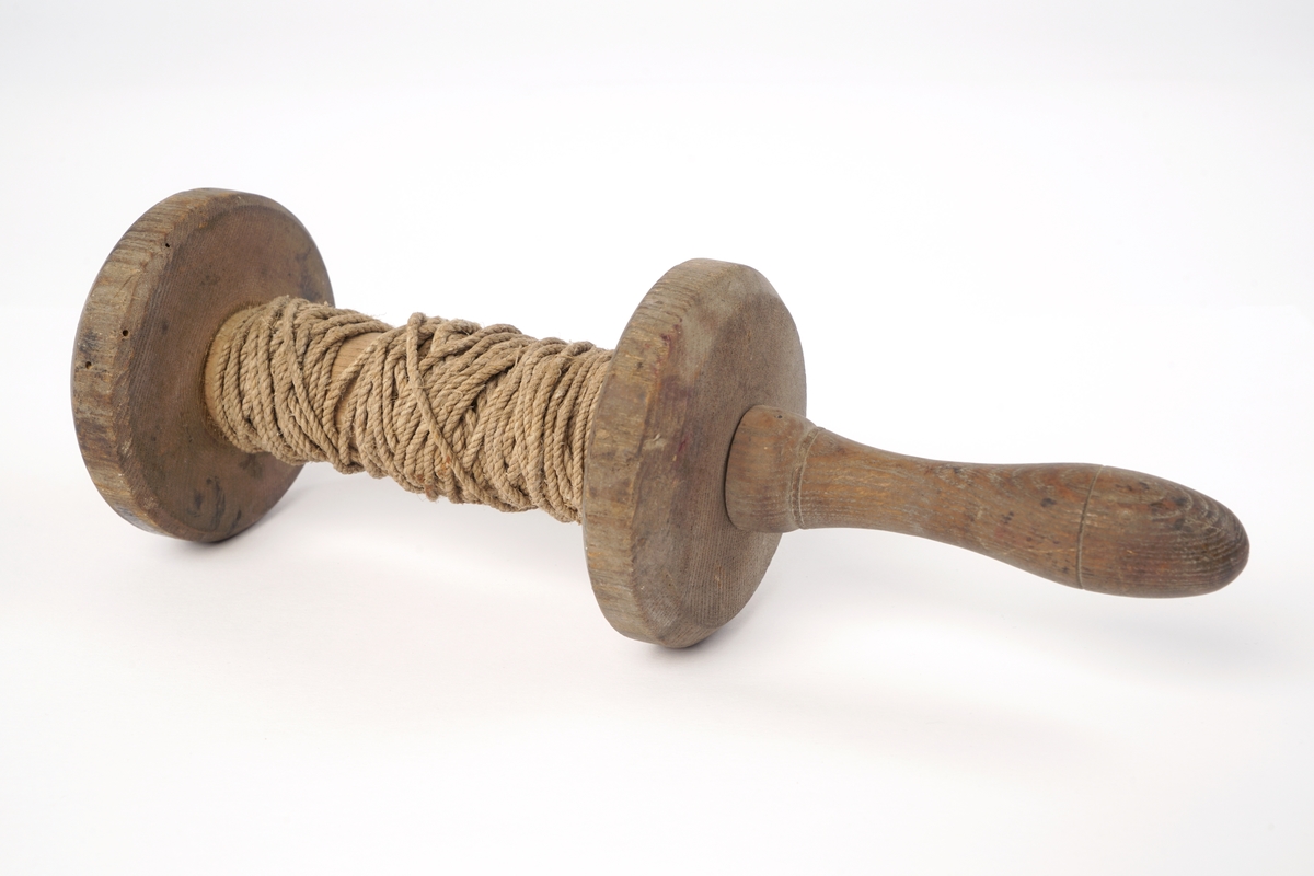En trådsnelle av tre med  trehåndtak i den ene enden.