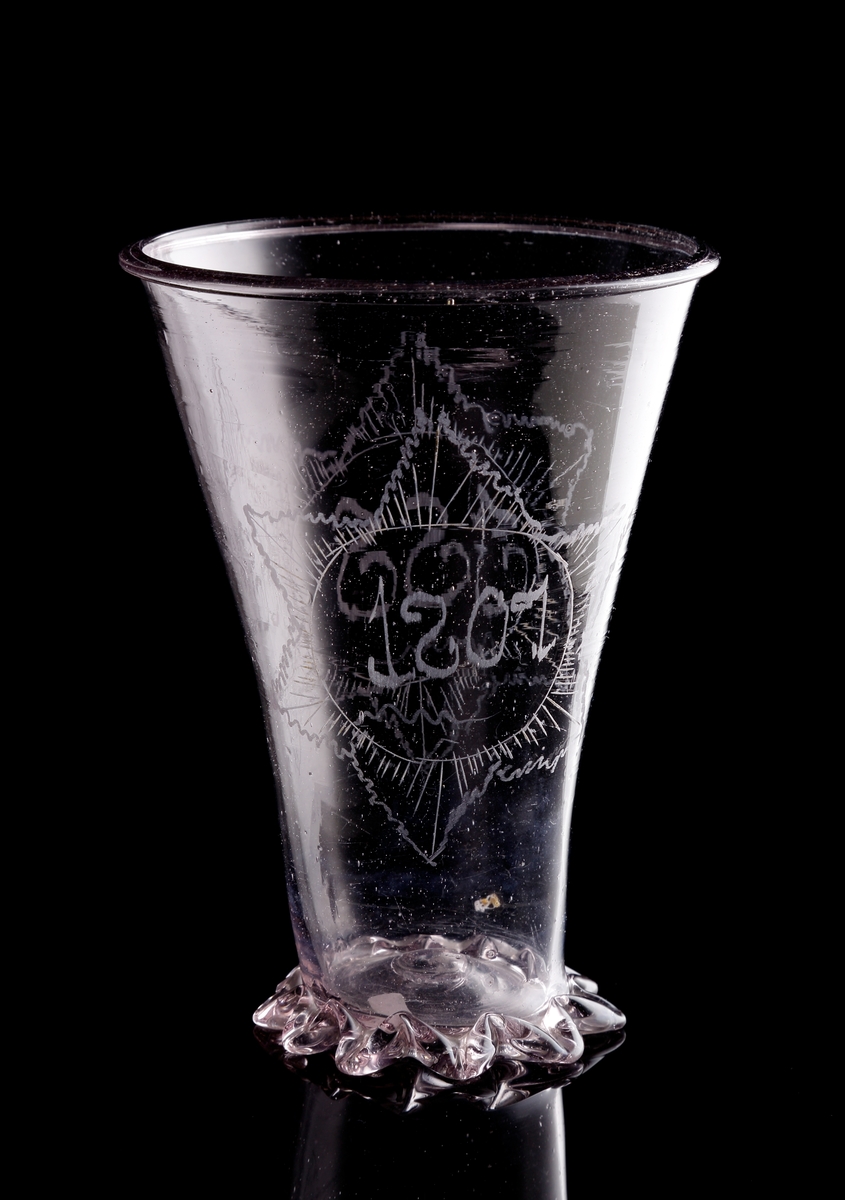 Bägare, s.k. "silverform".
Beskrivning: Pålagt, knipt glasband som bildar en fot. Graverad stjärna 
med initialerna "I.I.S." och ytterligare en stjärna med årtalet "1807".
Färg: Gråviolett klarglas.
Mått: Ovan angivna mått avser höjd och bredd upptill.
Inskrivet i huvudkatalogen 1937.