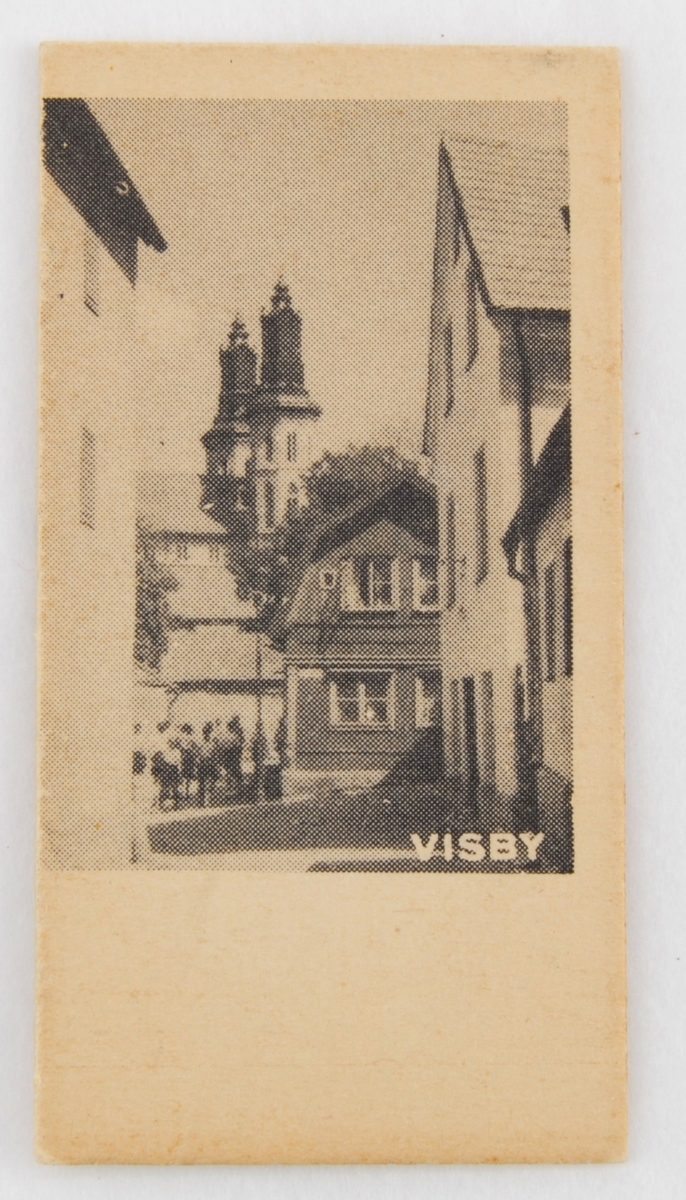 Viktbiljett i edmondsonformat med fotomotiv på ena sidan samt datum och vikt tillsammans med instruktioner på den andra.

Motivsidan har ett foto i stående format med bildtexten "VISBY" i nederkanten. Dock är fotot inte helt centrerat så det ligger ända ut i vänstermarginalen. Fotot är taget norrut från Ryska gränd strax söder om Övre och Nedre Finngränd med Domkyrkan i fonden. I bildens mitt syns gaveln på Övre Finngränd 1 och till vänster om det en grupp barn. Nedanför fotot finns en tom yta där det vanligen brukar finnas text eller stämplat datum. 

Den andra sidan har förtryckt text i svart och stämplade siffror i lila. Till vänster finns datumet följt av en pil som pekar mot en vågskala med vikttalen ovanför varandra.