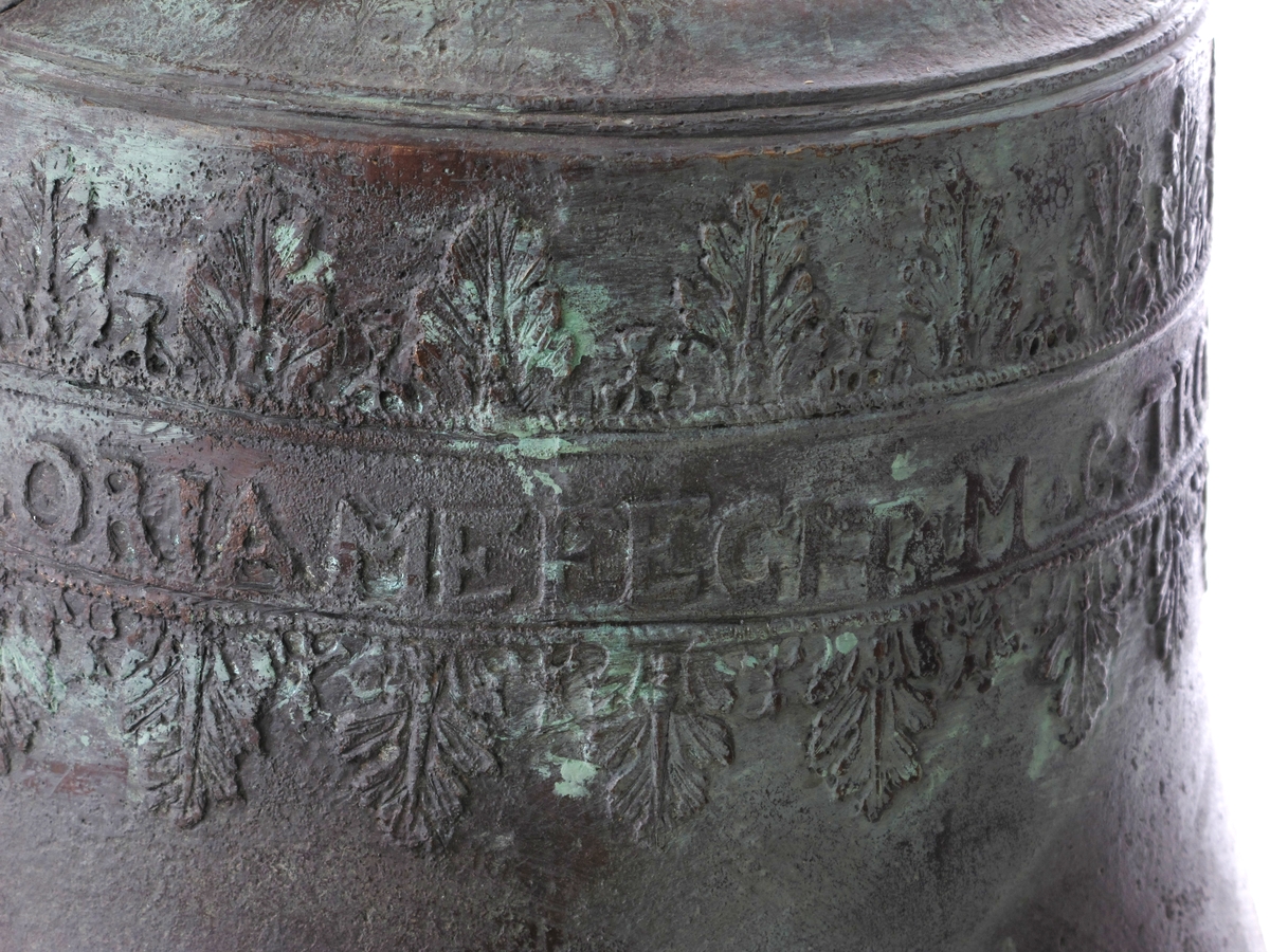 Støpt klokke, laget som kopi etter originalen. Støpt i klokkebronse på klokkestøperi i Sverige. Innstøpt tekst på klokkens side.