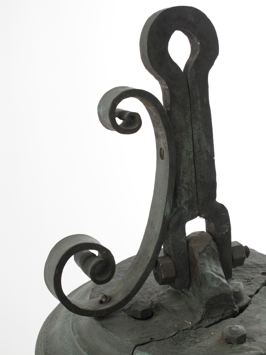 Støpt klokke, laget som kopi etter originalen. Støpt i klokkebronse på klokkestøperi i Sverige. Innstøpt tekst på klokkens side.