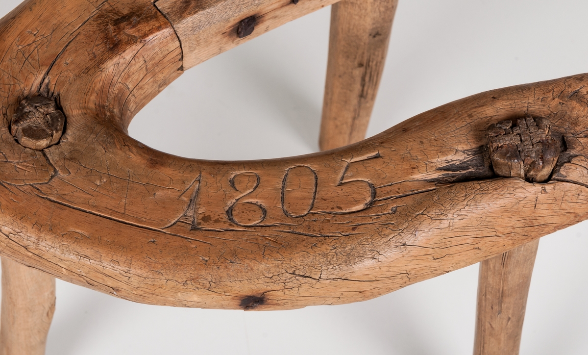 Krack/mjölkpall märkt 1805. Omålad. Undersidan märkt ALS.
Krokvuxen trä med 3 raka ben inborrade. Liten naturvuxen krok står upp på ena sidan.
