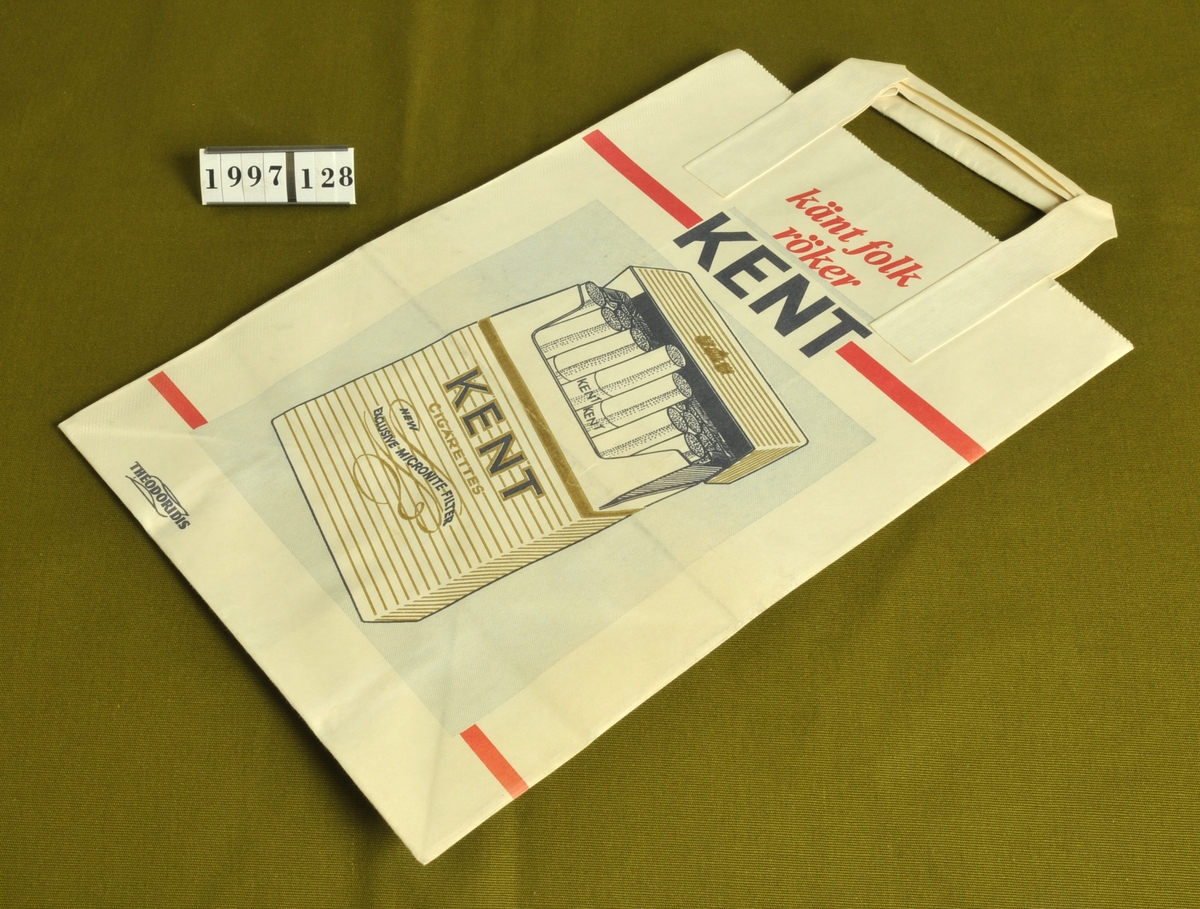 Bärkasse med reklam för cigarettmärket "Kent".
Vit med text och bild i rött, blått och guld.
Reklamtexten: "Känt folk röker Kent".
