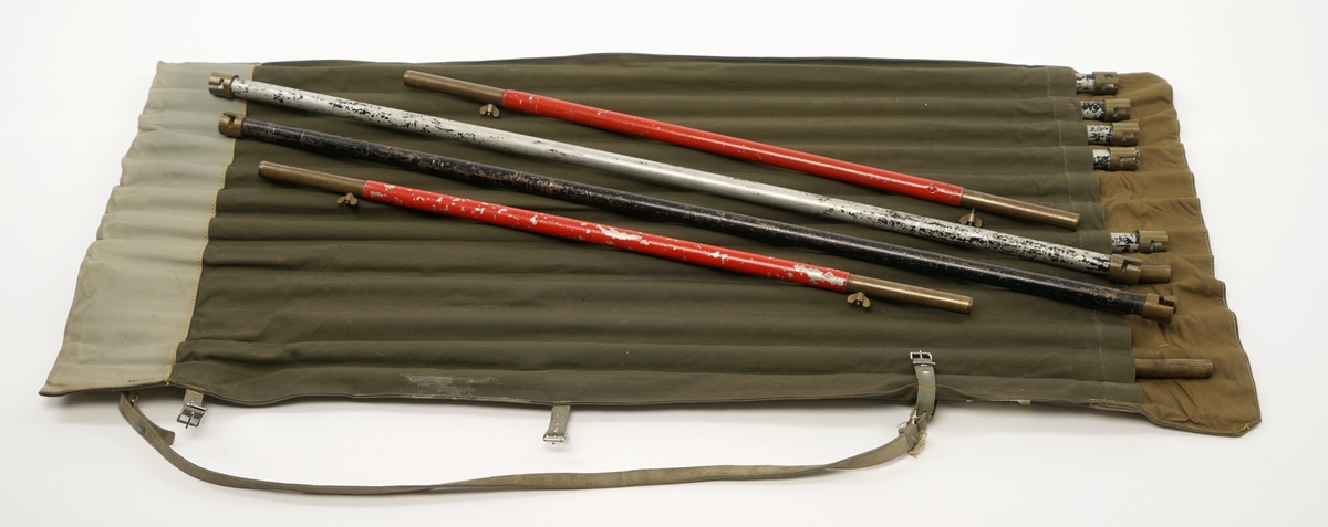 12 aluminiumsstenger konstruert for å kunne settes sammen.Disse ligger i hver sin lomme i  en lerretssekk. Sekken er forsterket med skinn i bunn og topp. Toppen kan brettes rundt åpningene/lommene til stengene. Sekken skal rulles sammen og låses med tre lærremmer med spenner. Sekken er også forsynt med bære/skulderrem i lær.