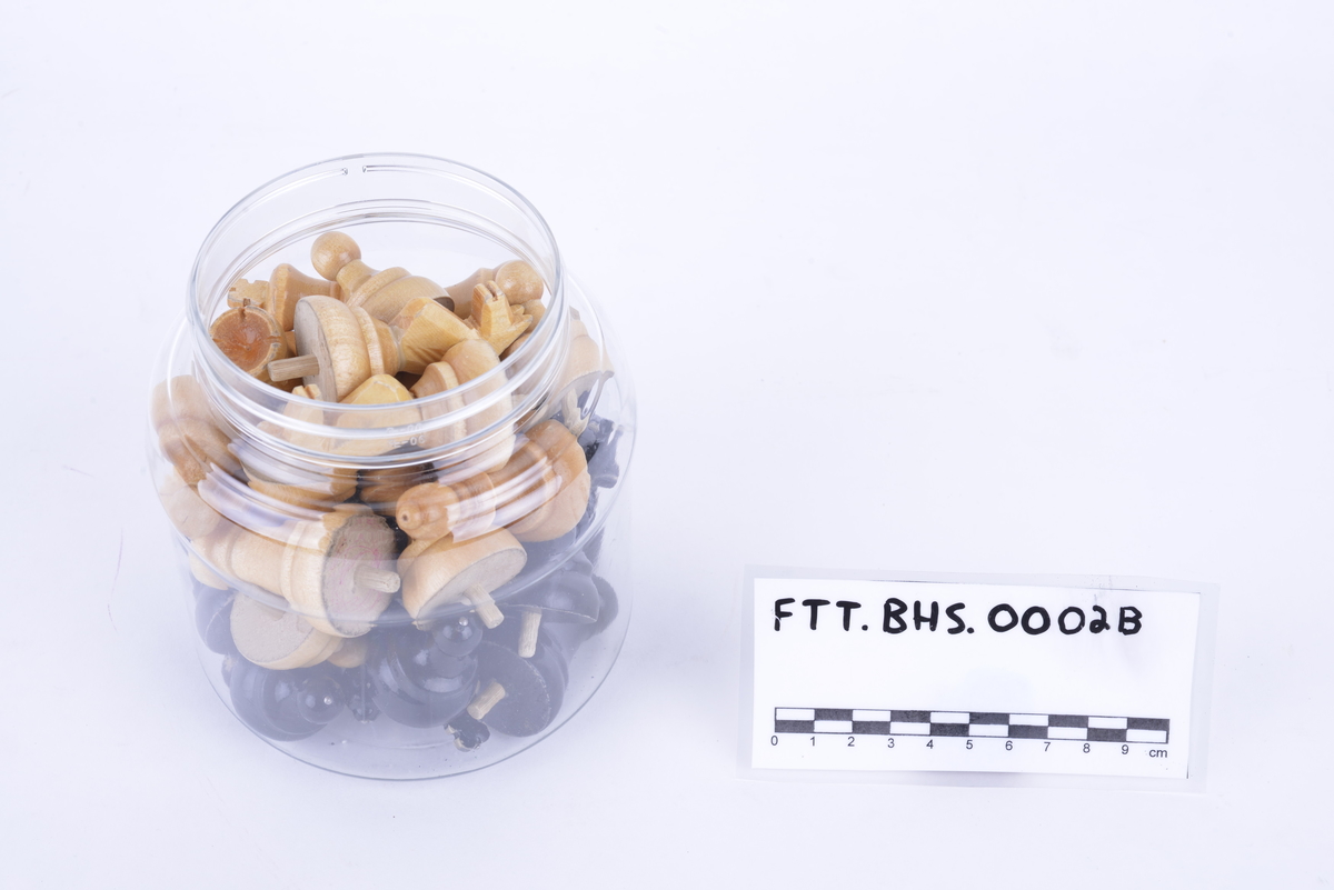 Sammenleggbar hengslet kasse i lakkert tre med brettspill på utsiden. Har tilhørende spillebrikker som ligger i en plastkrukke. 16 svarte og 16 i lakkert tre. Brikkene har pigger som kan stikkes ned i hull i brettet.