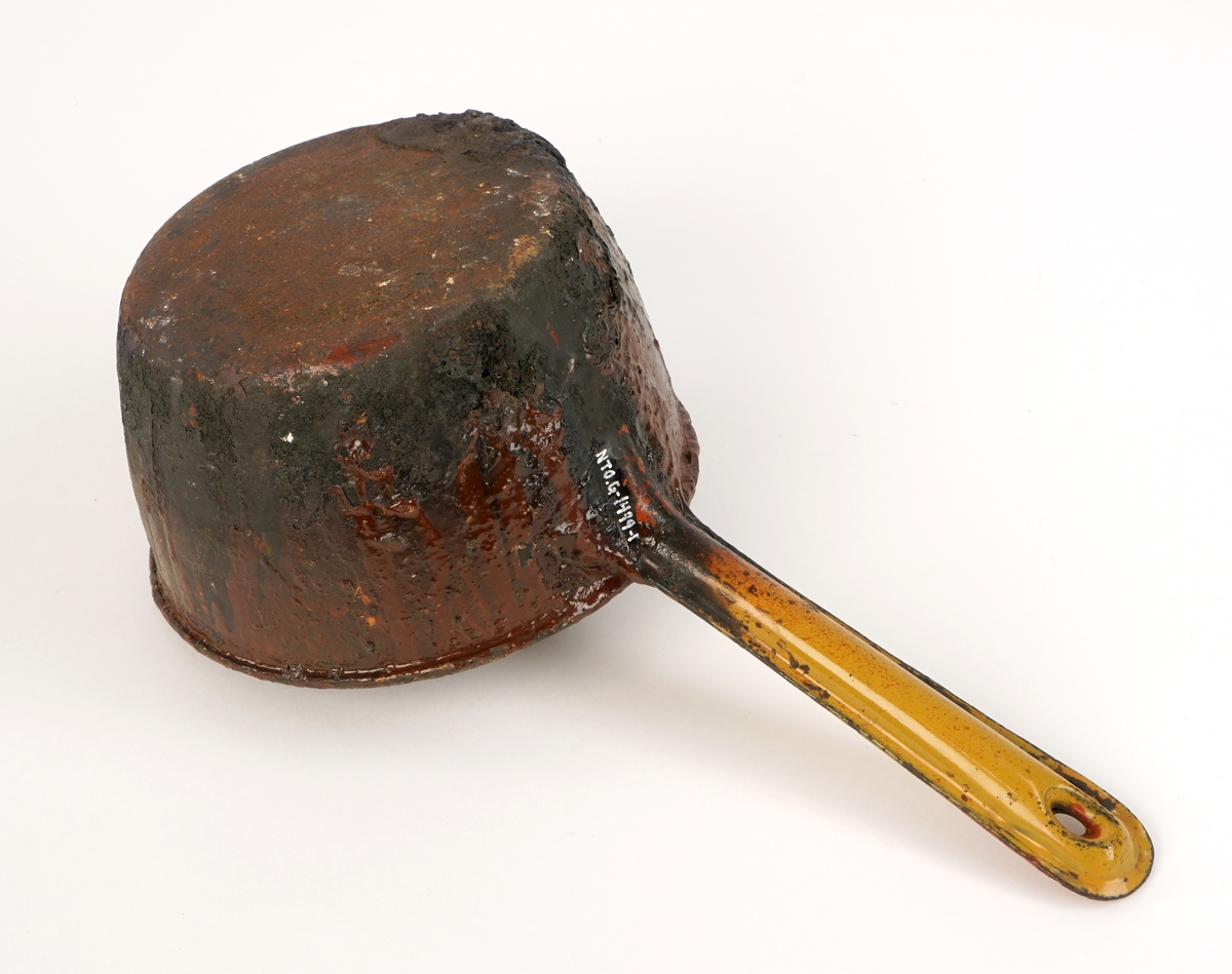 Rund kopp av metall med helletur og håndtak av metall.Inneholder lakkrester samt 15 løse lakkbiter