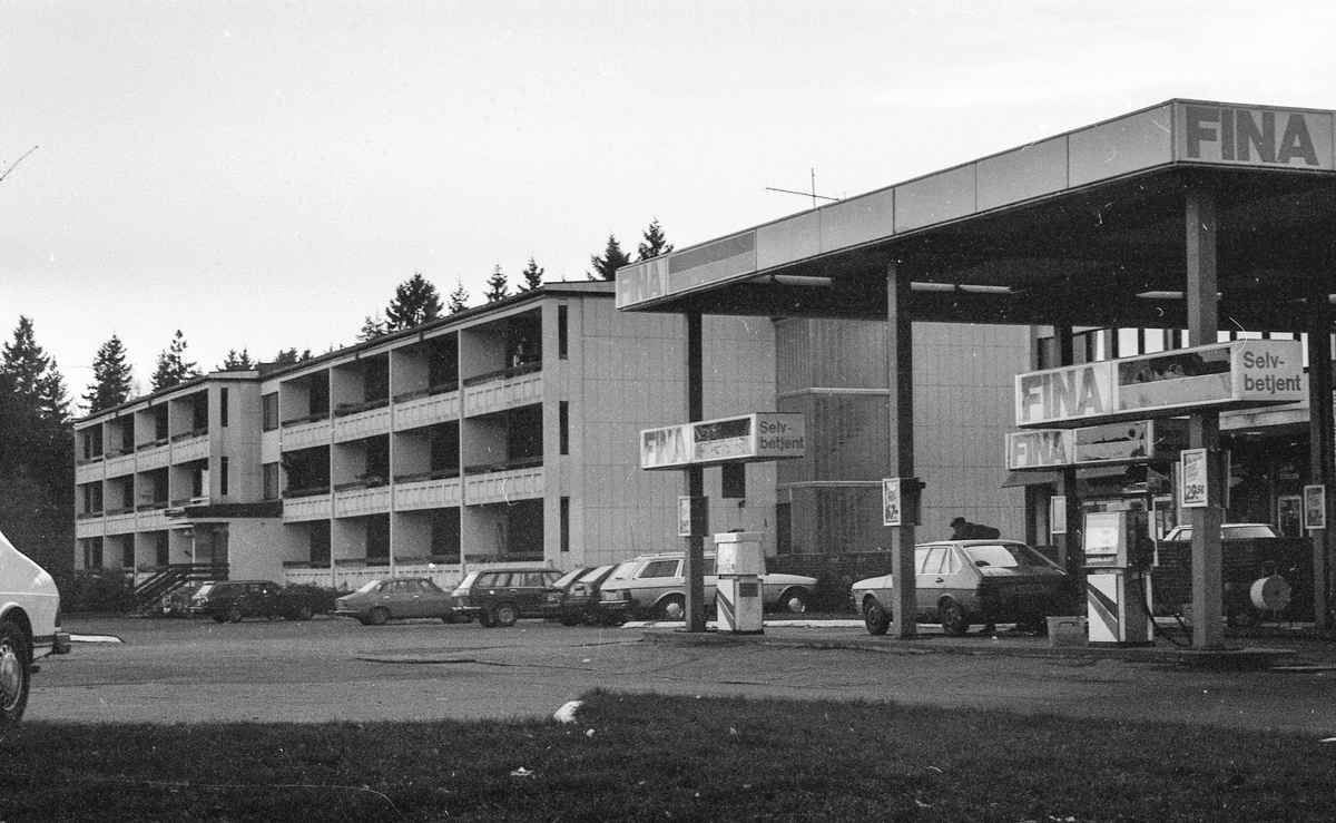 Brekkeveien 23 i Ås. To treetasjes boligblokker etter hverandre. Fina Bensinstasjon rett ved siden av.