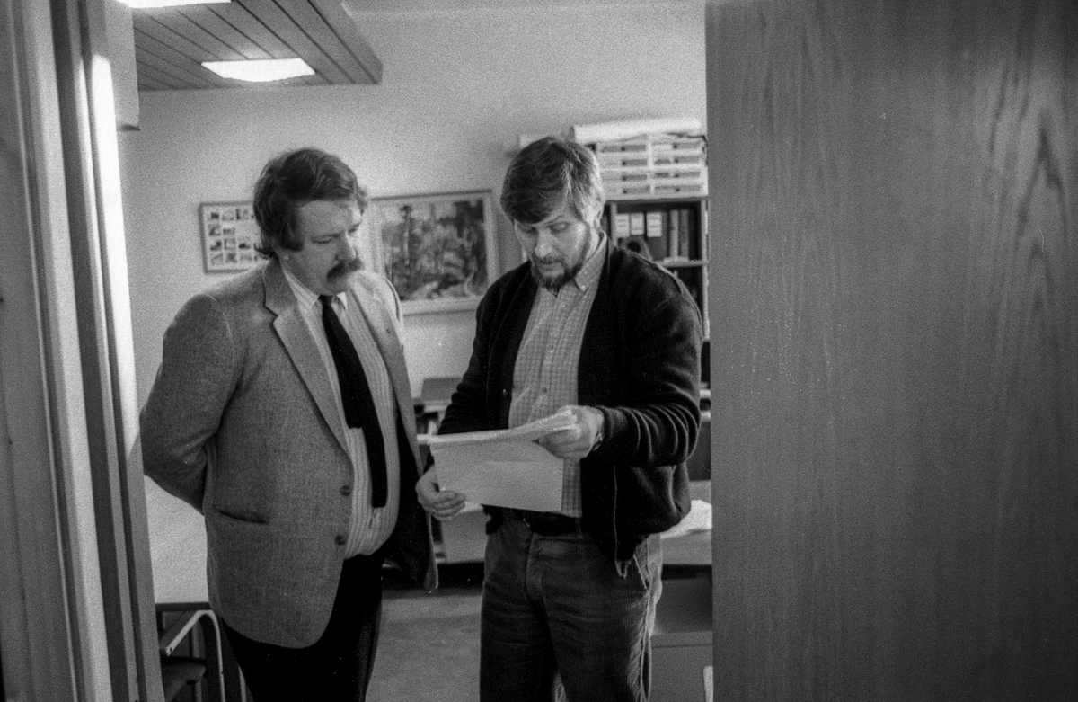 Ås trygdekontor stenger som en aksjon for å få utbedret dataanlegget som de er helt avhengige av. Salgsjef Olav Dalåsen i Norsk Data i samtale med trygdesjef Jan Espeland står i døråpningen med papirer.